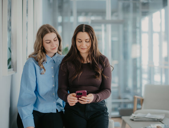 Zwei junge Frauen schauen auf ein Smartphone